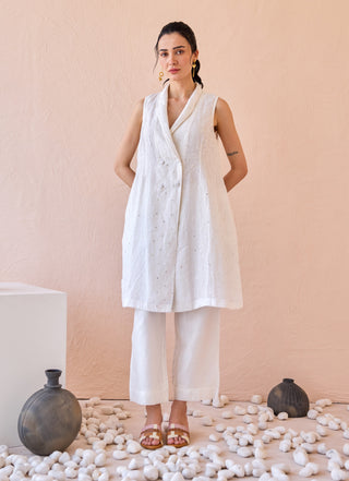 White sleeveless jacket and straight pants